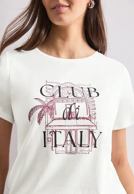 T-Shirt mit Rundhals und Artwork off white Frau trägt weißes T-Shirt mit 'Club di Italy'-Aufdruck, pastellfarbene Buchstaben und Palmenmotiv.