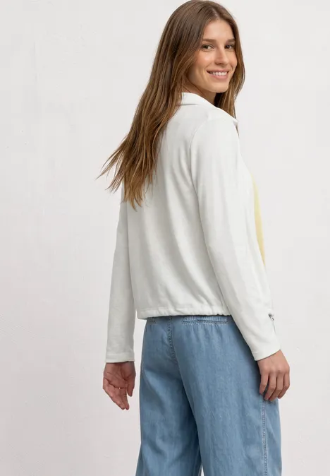 Lichtgewicht Langam-jack in linnenlook off white Vrouw in zijaanzicht met een lichte witte jas met lange mouwen en een blauwe spijkerbroek.