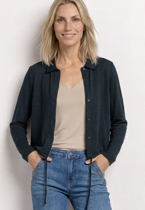 Leichte Langam Jacke in Leinen-Optik shadowed navy Eine Frau mit hellblondem Haar trägt eine Jeans, ein beiges Top und eine dunkle Strickjacke vor weißem Hintergrund.