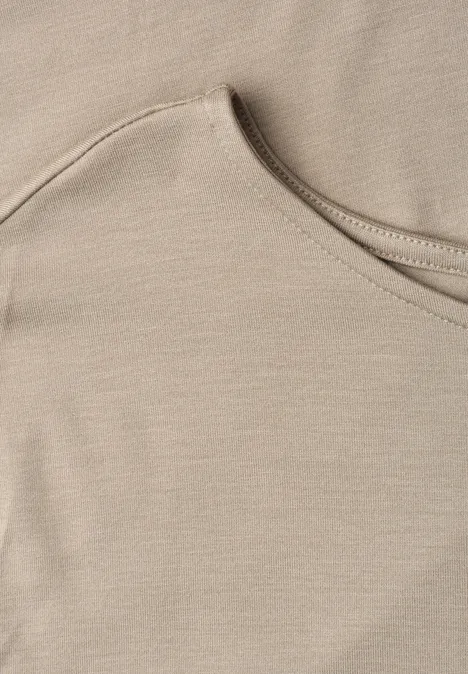 Nahaufnahme eines beigen T-Shirt-Ausschnitts aus weichem Stoff.