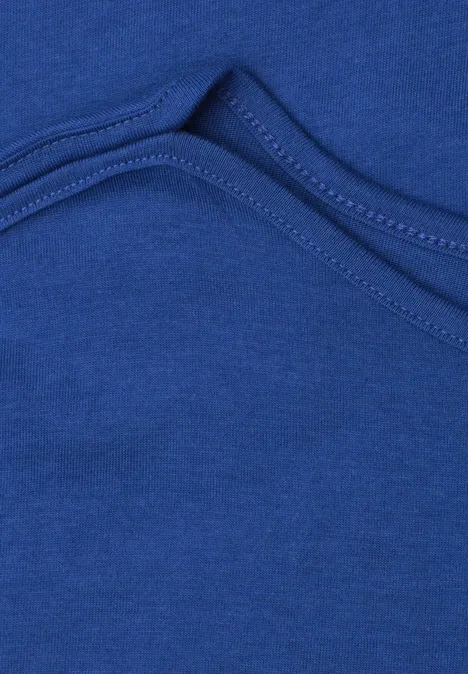 Basic shirt met boothals amparo blue Close-up van een gebogen naad in blauw textiel.