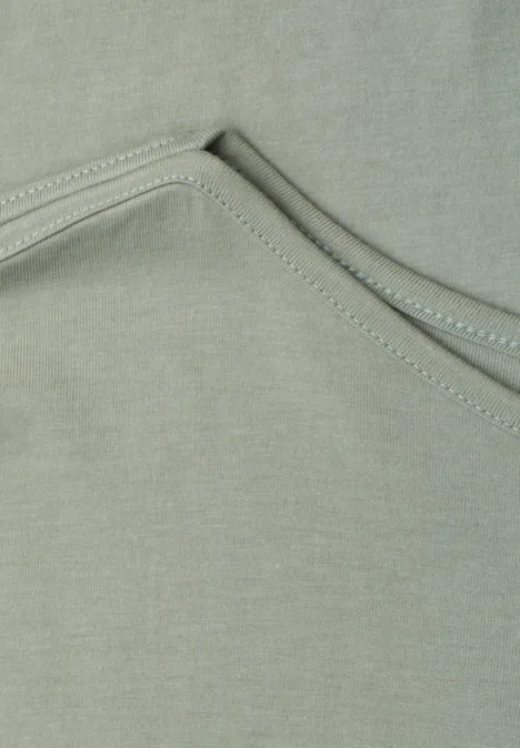 Basic shirt met boothals mint leaf Close-up van grijsgroen textiel met decoratieve stiksels.