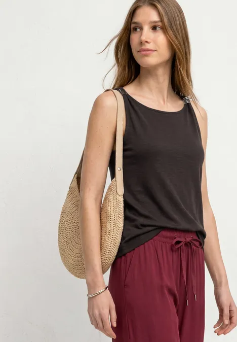 Top mit U-Boot-Ausschnitt und Schulterdetail espresso brown Frau trägt ärmelloses dunkelbraunes Top, weite rote Hose mit Kordelzug und runde Strohtasche vor hellem Hintergrund.