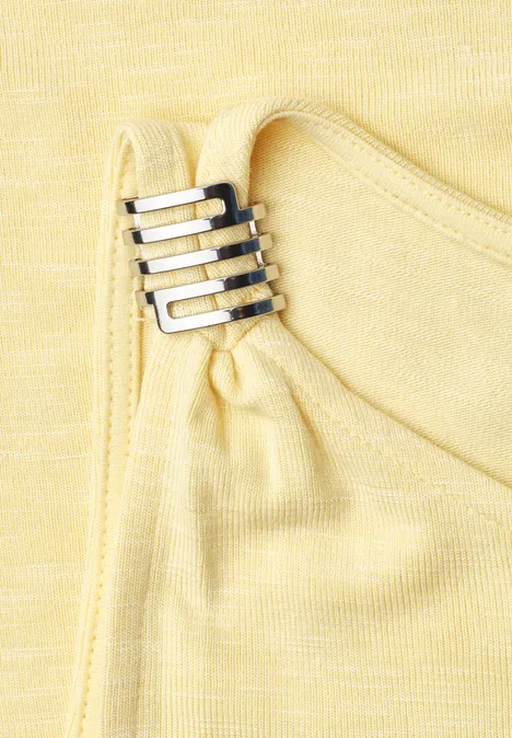 Top mit U-Boot-Ausschnitt und Schulterdetail soft yellow Nahaufnahme gelben Stoffs mit dekorativem Metallverschluss in Silber.