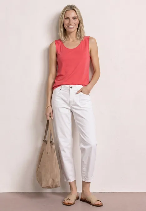 Top aus Jersey mit Elastiksaum sunset red Eine Frau lehnt an der Wand und trägt ein rotes Top, weiße Hose, Sandalen und eine große Stofftasche.