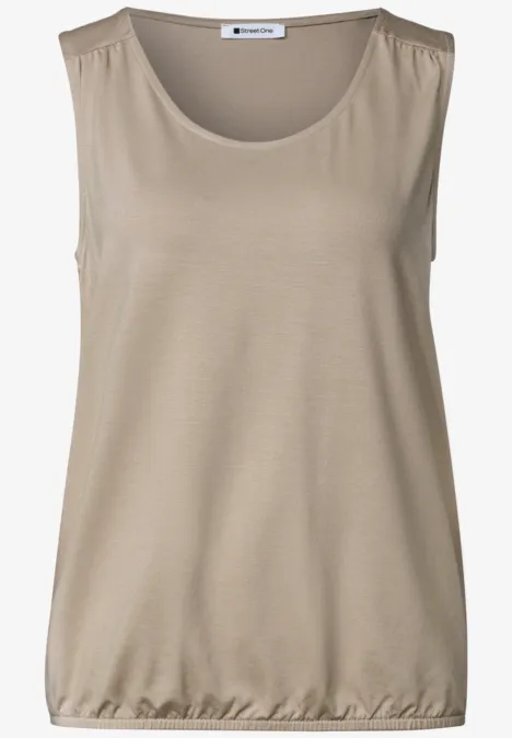Haut sans manches beige à encolure ronde et ourlet élastique.