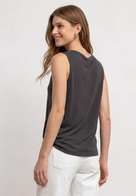 Top aspect soyeux avec décolleté cascade espresso brown Jeune femme de dos portant un débardeur noir et un pantalon blanc.