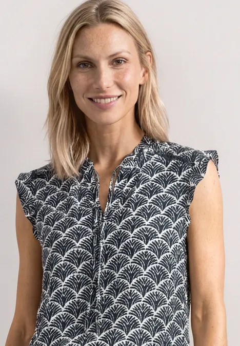 Top met verschillende texturen en gehaakte details shadowed navy Damesmouwloos top met ritssluiting en witte waaierprint op donkerblauwe ondergrond.
