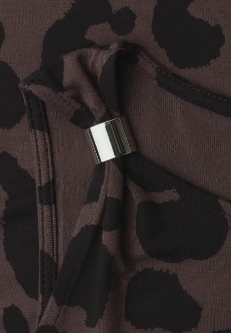 Nahaufnahme eines braun-schwarz gepunkteten Stoffes mit Kordelzug und silbernem Metallakzent.
