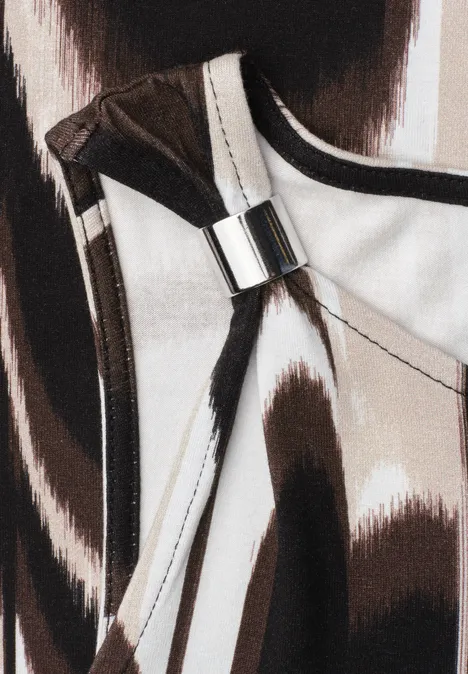 Gros plan d'un sac à main au motif abstrait brun et blanc avec boucle argentée