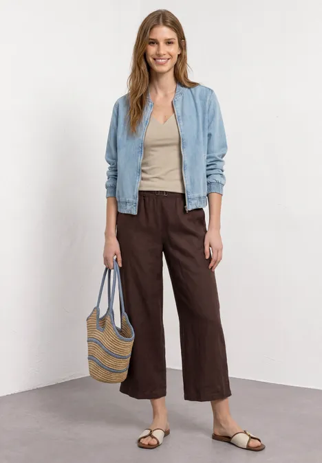 Basic Top mit Herzausschnitt sepia sand Frau in blauer Jacke, beigem Top, brauner Culotte, Sandalen und Korbtasche vor hellem Hintergrund.