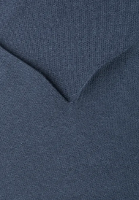 Close-up van een donkerblauw V-hals T-shirt met fijne stofstructuur.