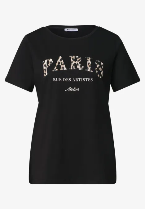 Schwarzes T-Shirt mit Aufdruck „Paris Rue des Artistes“ in weißer Schrift.