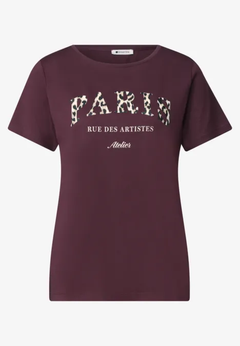 T-Shirt mit Wording Artwork rustic rouge Ein bordeauxrotes T-Shirt mit Aufdruck 'PARIS RUE DES ARTISTES' in floralen Buchstaben.