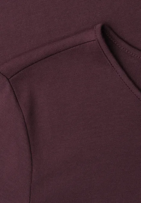 Basic Shirt met ronde hals in Unifarbe rustic rouge Close-up van een bordeauxrood kledingstuk met zichtbare schouder- en halsnaad.