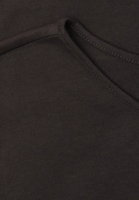 Basic Shirt met ronde hals in Unifarbe black coffee Close-up van een zwart kledingstuk met zichtbare naad en een zakopening.