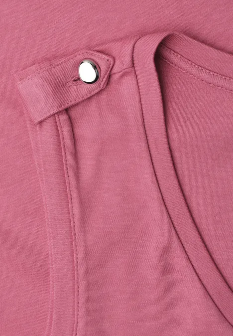 Nahaufnahme eines rosa ärmellosen Oberteils mit silbernem Druckknopf an der Schulter.