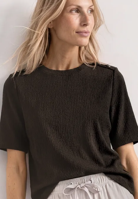 T-Shirt mit Rundhals und Knopfdeatils black coffee Frau in schwarzem, strukturiertem T-Shirt und grauer Hose