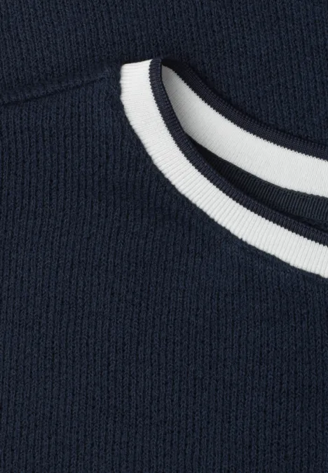 Close-up van een marineblauwe trui met ronde hals en witte strepen.