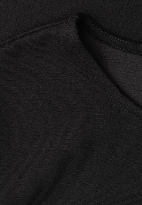 T-Shirt mit Rundhals und Volant-Detail Black Nahaufnahme von schwarzem Stoff mit Naht und Tasche.