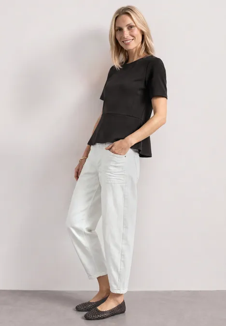 T-Shirt mit Rundhals und Volant-Detail black coffee Frau in schwarzem T-Shirt, weißen, hohen Hosenbeinen und schwarzen Ballerinas, steht seitlich vor hellem Hintergrund.