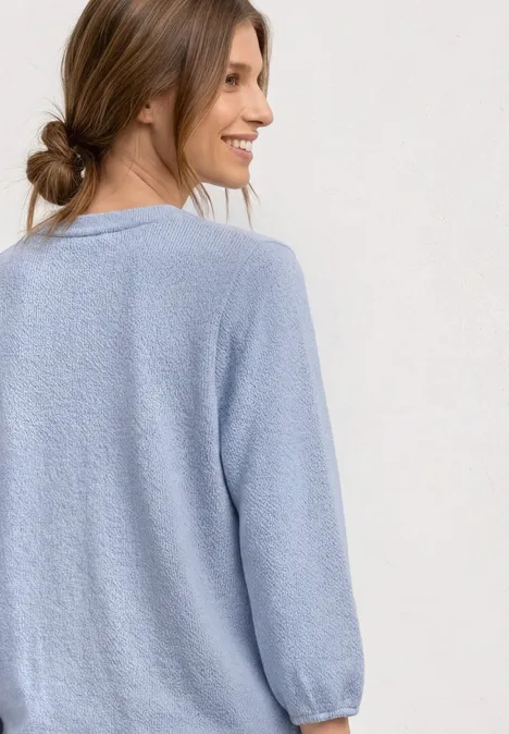 3/4-Arm Shirt mit Rundhals im Strick-Look whispery blue mel. Eine Frau im hellblauen Strickpullover mit langen Ärmeln, Rücken zur Kamera gewandt.