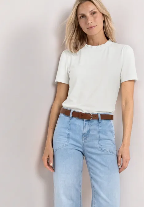 T-Shirt mit Rundhals und Rüschendetails off white Eine Frau trägt ein weißes T-Shirt und hellblaue Jeans mit braunem Gürtel.