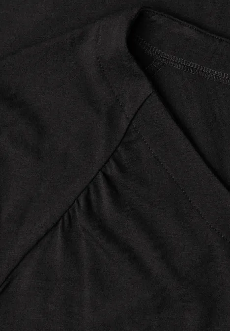 Zwart T-shirt met zichtbare plooien en zachte katoenstructuur.
