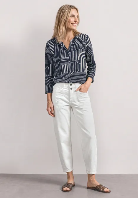 3/4-Arm Shirt mit Split Neck und Print darkest blue Frau in gemustertem Langarmshirt, weißen Jeans und braunen Sandalen vor neutralem Hintergrund.