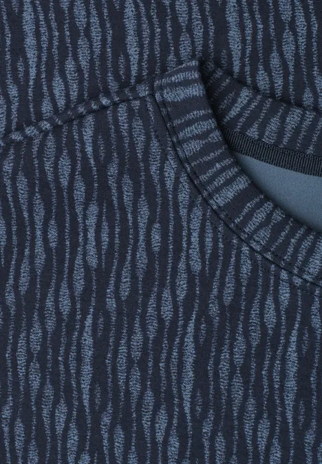 Close-up van donkerblauw textiel met lichtblauwe, golvende patronen en een zak.