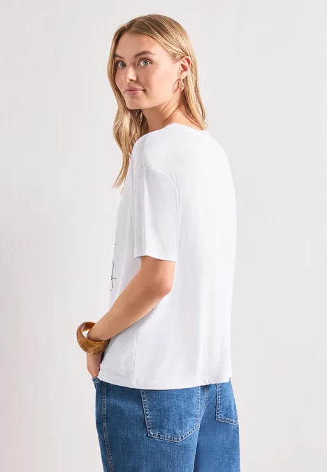 Vue latérale d'une femme portant un t-shirt blanc et un jean bleu sur fond clair.