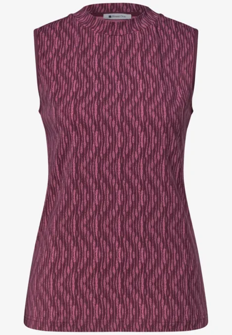 Top sans manches rose avec motif abstrait ondulé.