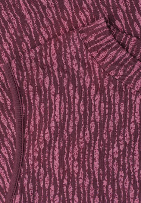 Gros plan sur un tissu violet et rose à motif ondulé, détail de poche sur un vêtement