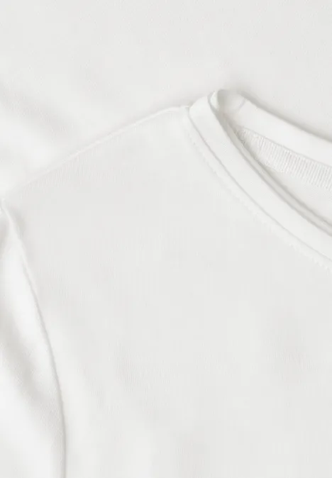 Basic T-Shirt mit Rundhals in Unifarbe off white Nahaufnahme eines weißen T-Shirts mit Rundhalsausschnitt und feiner Baumwollstruktur.