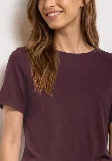 Basic Shirt met ronde hals in Unifarbe rustic rouge Een vrouw draagt een effen t-shirt met korte mouwen in donkerpaars.