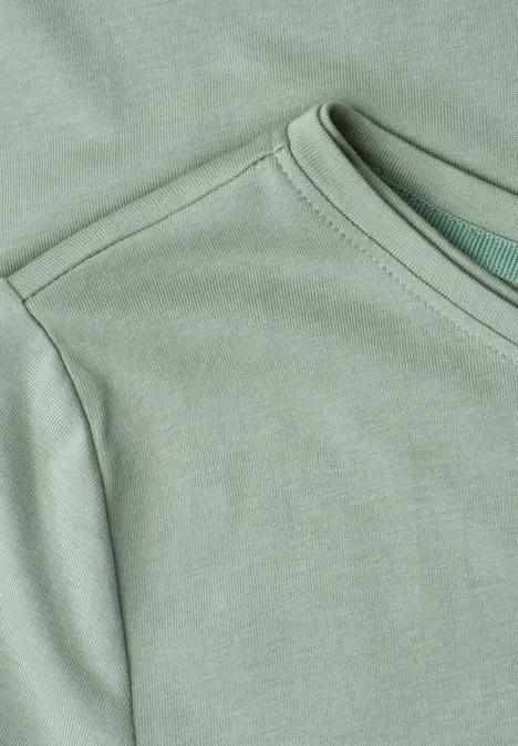 Basic Shirt met ronde hals in Unifarbe eucalyptus green Close-up van een lichtgroen T-shirt met ronde hals en schoudernaden.