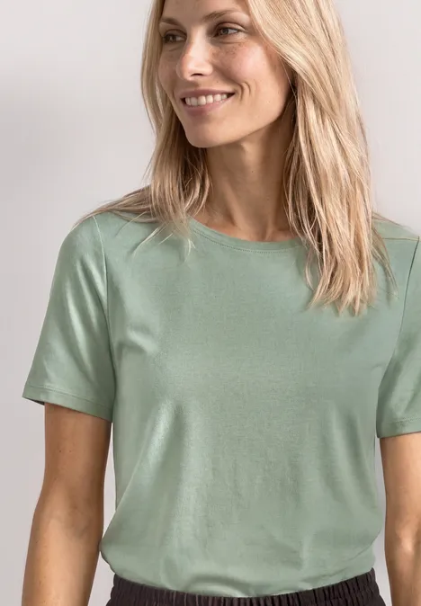 Basic Shirt met ronde hals in Unifarbe eucalyptus green Vrouw met lang blond haar draagt een eenvoudig mintgroen T-shirt.