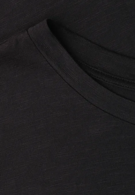 Nahaufnahme eines schwarzen T-Shirts, Fokus auf Rundhalsausschnitt und feine Stoffstruktur.