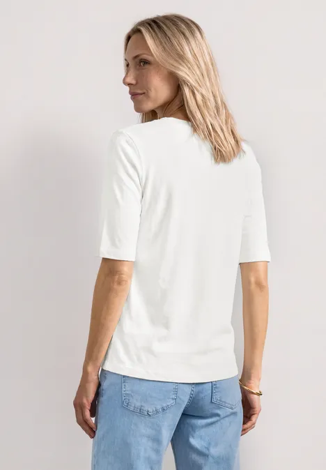 Basic T-Shirt mit Rundhals in Unifarbe off white Rückansicht einer Frau mit schulterlangem blondem Haar, weißem Halbarmshirt und blauen Jeans.