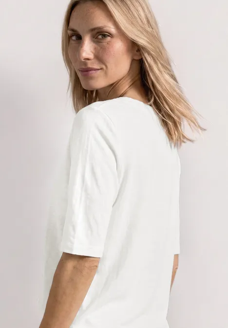 Basic T-Shirt mit Rundhals in Unifarbe off white Seitlich abgebildete Person mit halblangem blondem Haar trägt ein schlichtes weißes T-Shirt.