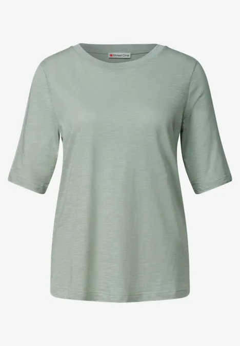 Ein schlichtes, hellgrünes T-Shirt mit halbhohen Ärmeln und lockerem Schnitt.