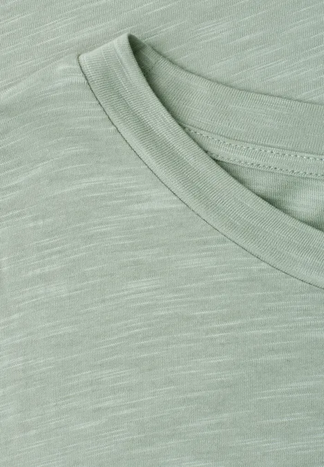 Nahaufnahme eines hellgrünen T-Shirts mit feiner Melierung und Rundhalsausschnitt.
