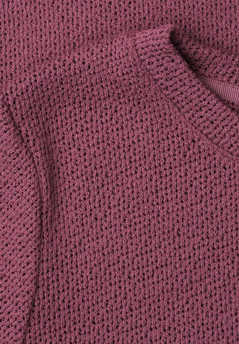 Close-up van een rosé grofgebreide trui.