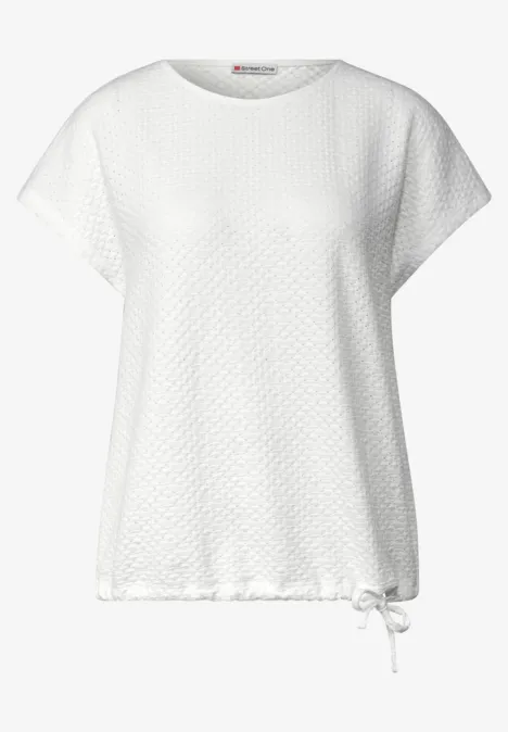 Biały T-shirt z krótkim rękawem, luźny krój, subtelny wzór rombów i sznurek w dole.