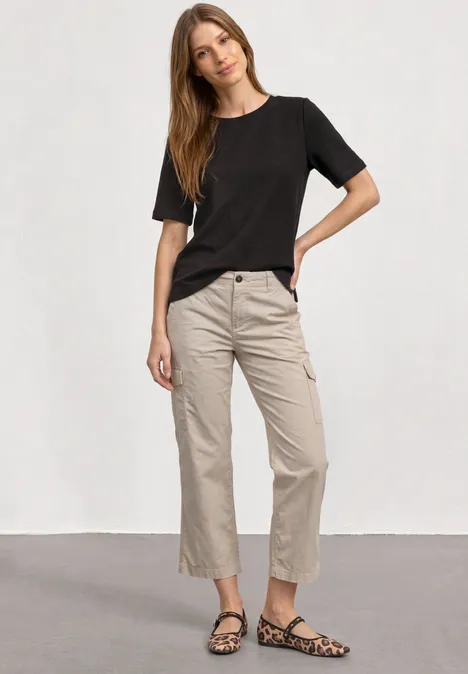 T-Shirt mit Rundhals und Struktur black coffee Frau in schwarzem T-Shirt, beigen knöchellangen Hosen und Leo-Musterschuhen steht vor hellem Hintergrund.