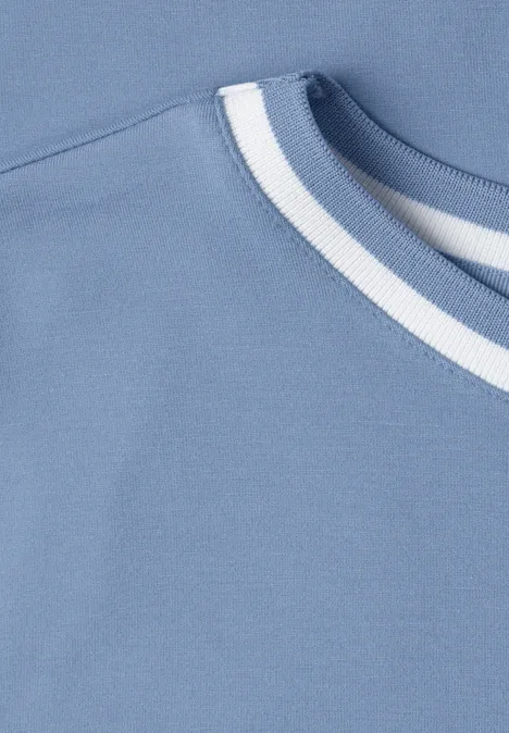 T-shirt à col rond avec détail contrasté northern blue Nahaufnahme eines hellblauen Shirts mit weißem und dunkelblauem Streifen am Rundhalsausschnitt.