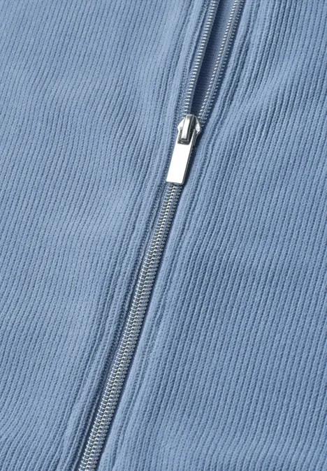 Gilet zippé à col rond effet velours côtelé northern blue Gros plan sur un tissu bleu clair avec une fermeture éclair argentée