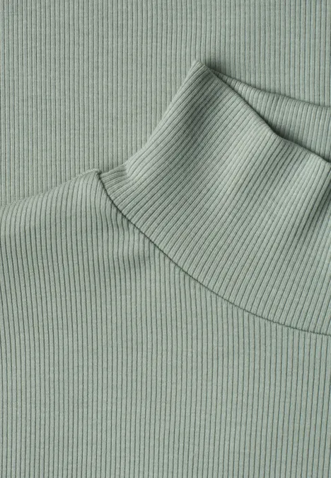 T-shirt à col roulé en maille côtelée eucalyptus green Nahaufnahme eines pastellgrünen, gerippten Rollkragenpullovers.