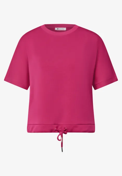 Een fuchsiaroze T-shirt met korte mouwen en een verstelbaar aantrekkoord aan de zoom.