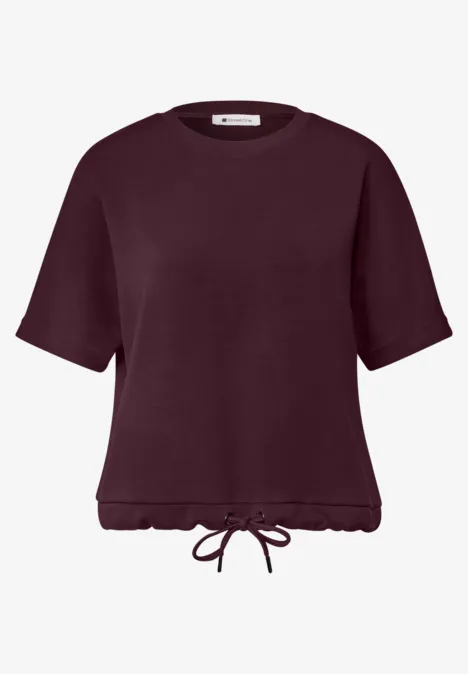 T-shirt à col rond avec un aspect soyeux rustic rouge Haut manches courtes bordeaux avec ourlet froncé et cordon de serrage.